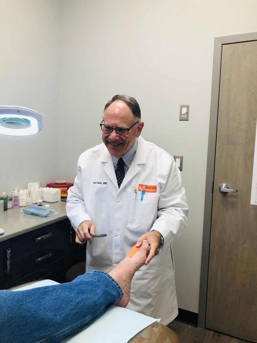 Podiatrist Dr. Arden Smith treating a patient's foot at Advanced Foot Care on Long Island, NY.