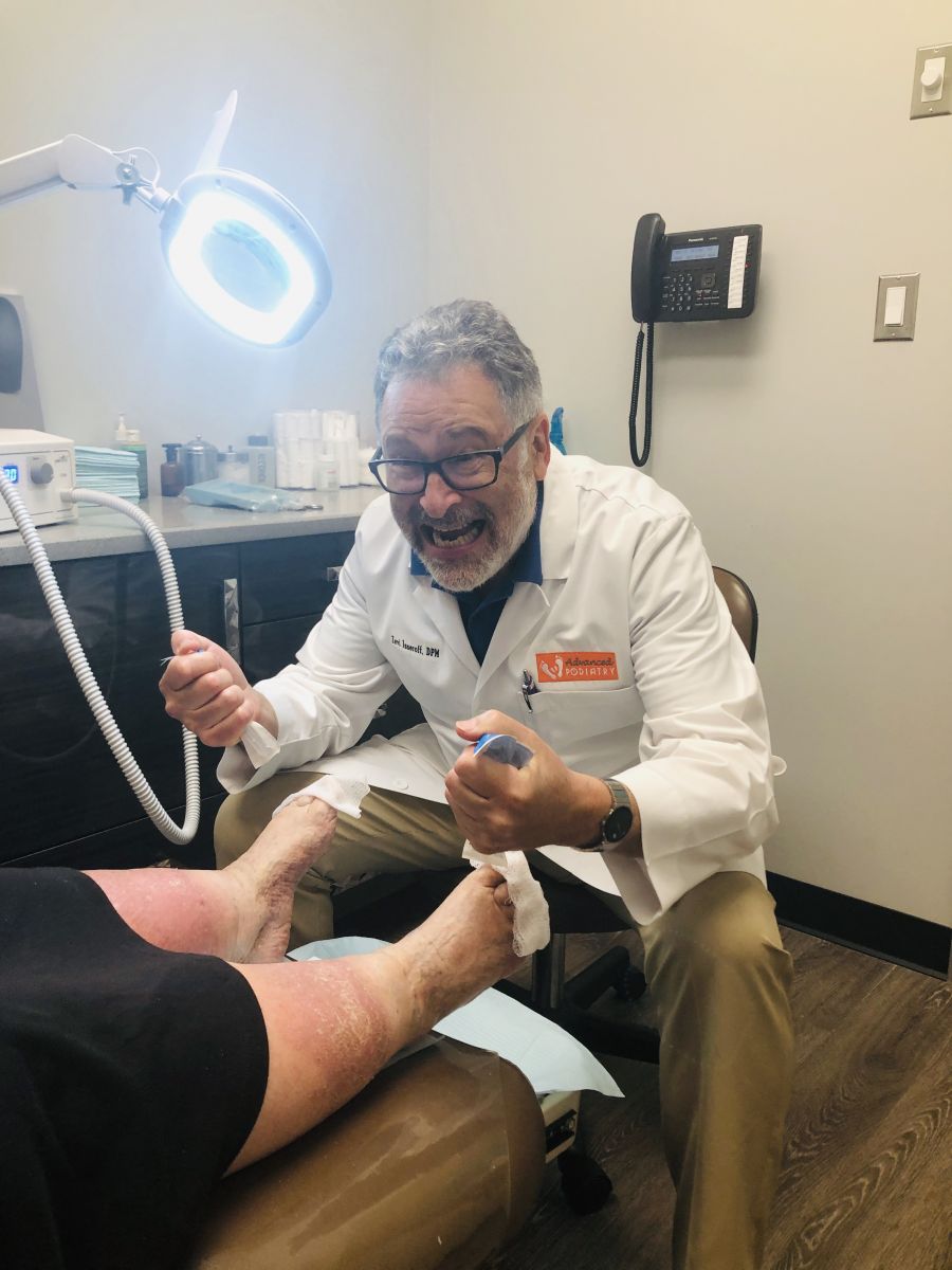 Podiatrist Dr. Zevi W. Isseroff consulting a patient at Advanced Foot Care in Maspeth, NY.